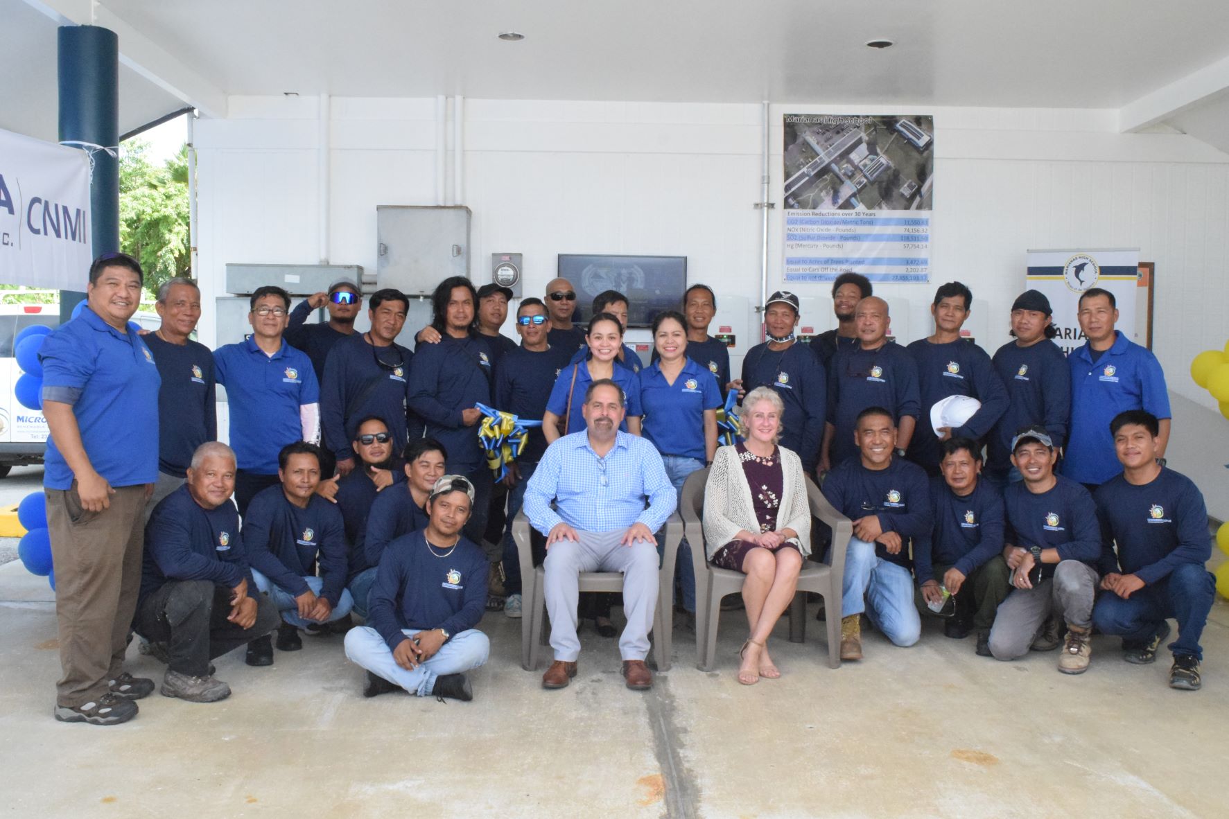 Micronesia Renewable Energy Inc. Chief Operations Officer Jeffrey Voacolo and Chief Executive Officer Tracy Voacolo, center seated, pose with their staff following the ribbon-cutting ceremony for the newly installed solar energy system at Marianas High School on Wednesday.