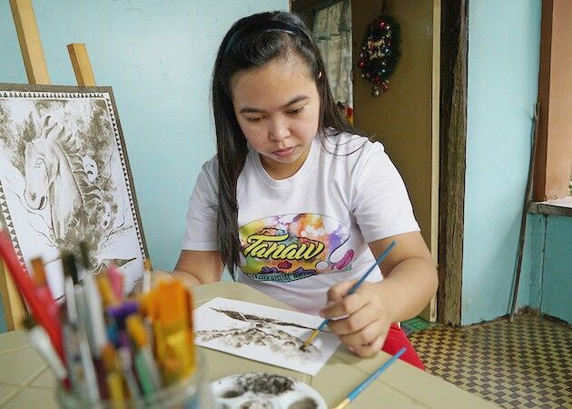 Filipina artist Janina Sanico uses volcanic ash she found in her yard to paint images of Taal volcano inside her home in Tanauan, Batangas province, south of Manila, the Philippines on Jan. 24, 2020. REUTERS