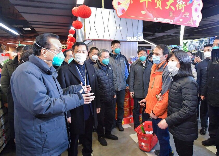 Chinese Premier Li Keqiang, left, speaks with people at a supermarket in Wuhan in central China’s Hubei province, Monday. AP
