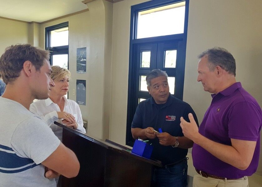George Anson, right, gestures as he talks to NMI Museum director Danny Aquino, second right, at the museum on Tuesday while Anson’s wife Kirsty, second left, and son Douglas, left, look on. Photo by Bryan Manabat