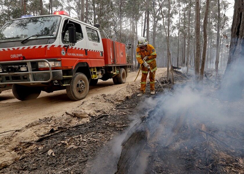 A firefighter patrols a controlled fire as he and his colleagues work at building a containment line at a wildfire near Bodalla, Australia, Sunday. AP