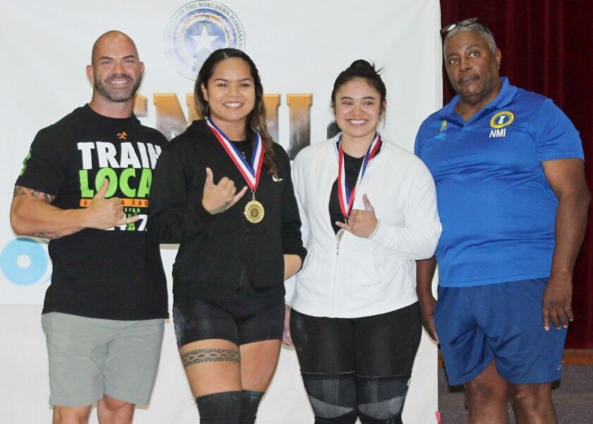 Rea Camacho, 2nd left, and Danica Guevarra, 2nd right, pose with Latte Built owner Derek Cutting and CNMI Weightlifting Federation’s John Davis. Photo by James F. Sablan Jr.