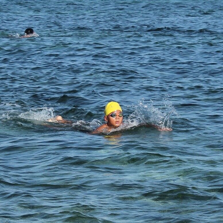 Justin Ma makes his way to the shore  in the 1k category of the 14th Meek & Mighty Swim at the Kanoa Resort beach on Saturday. Photos by James F. Sablan Jr.