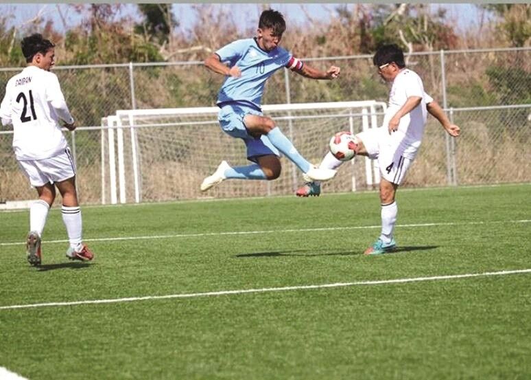 Sunjoon Tenorio of the NMI Men’s Soccer National Team leaps past a Korean Football Association on Saipan defender. Contributed photo