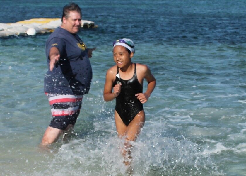 Maria Batallones finishes first in the 3k category of the 14th Meek & Mighty Swim at the Kanoa Resort beach on Saturday. Photos by James F. Sablan Jr. 