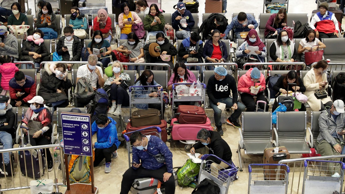 Passengers, some wearing protective masks, wait for their flights at Manila’s international airport on Monday. AP