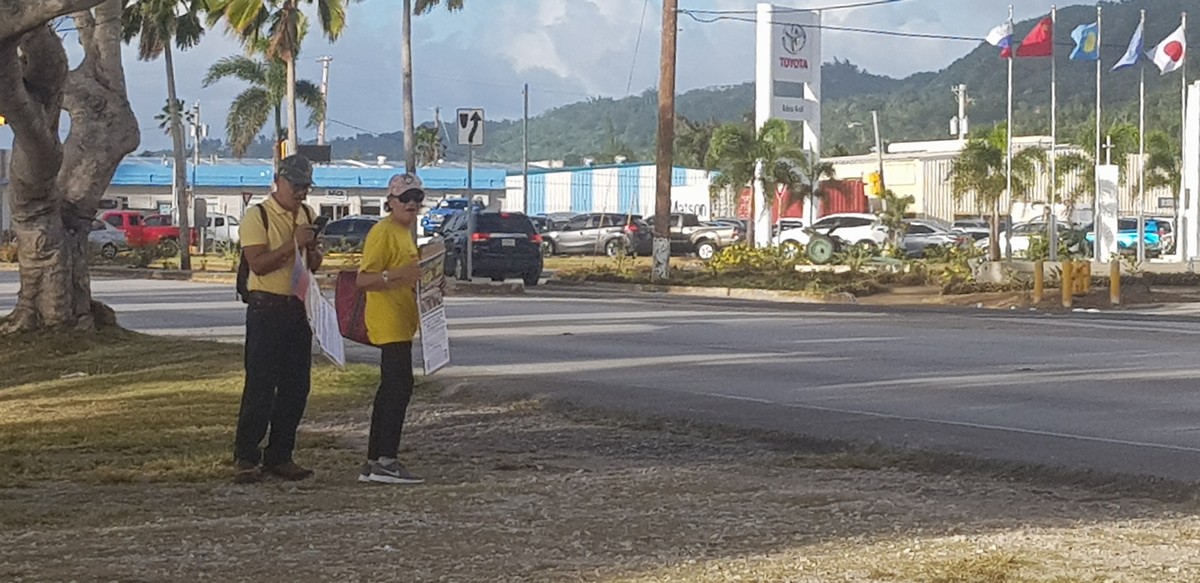At the San Jose intersection, two members of the National Youth Movement for the West Philippine Sea display placards expressing support for the renewal of the ABS-CBN network franchise in the Philippines and the 34th anniversary of the People Power revolution that ended the 20-year presidency of Ferdinand E. Marcos. Photo by Junhan B. Todiño