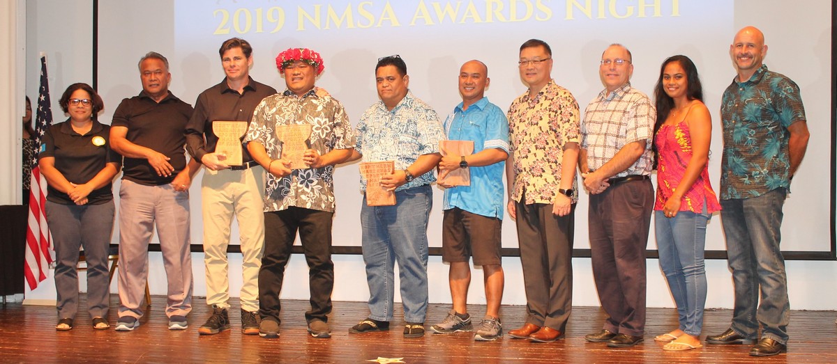 Hall of Fame inductees Chris Nelson, Jerry Ayuyu, Rufino Aguon (represented by Lawrence Camacho) and Louie Wabol (represented by Robin Sapong) pose with their trophies alongside the Northern Marianas Sports Association board members during Wednesday’s NMSA Annual Banquet at the Fiesta Resort & Spa. Photo by James F. Sablan Jr. 