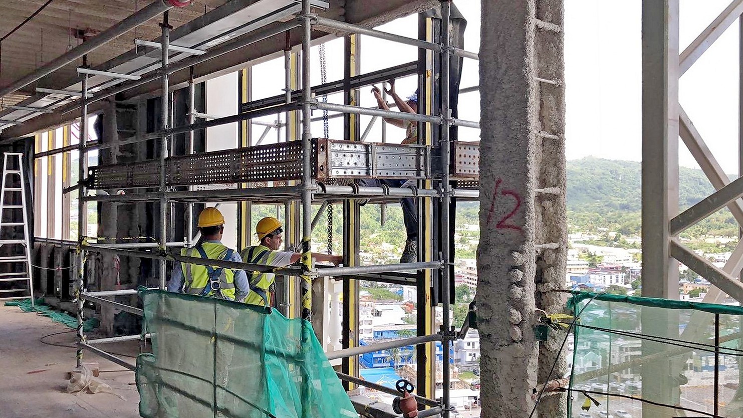 Construction workers install a glass wall on the façade of the Imperial Palace hotel tower. Contributed photo