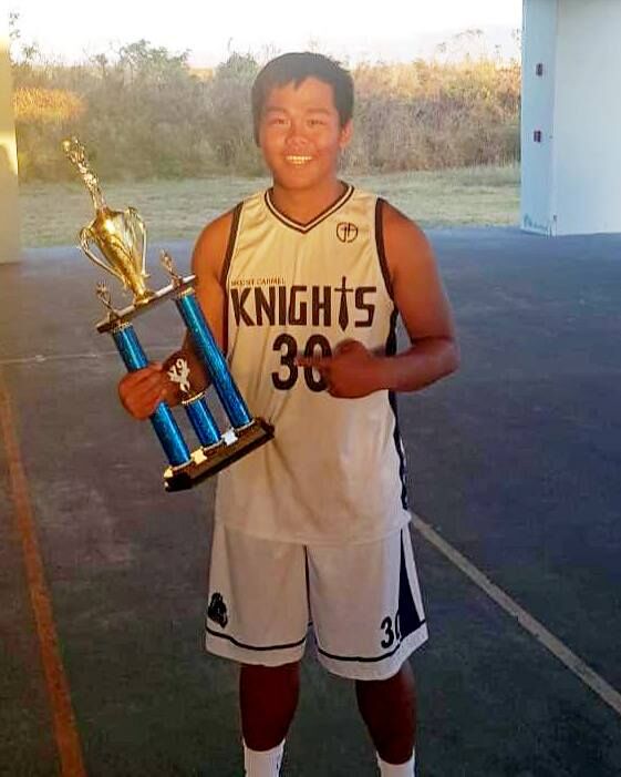 Mount Carmel School’s Angelo Factor holds a trophy after his team won the Commonwealth Coalition of Private Schools Association Basketball League hosted by John Blanco at the Koblerville Basketball Gym. Contributed photo