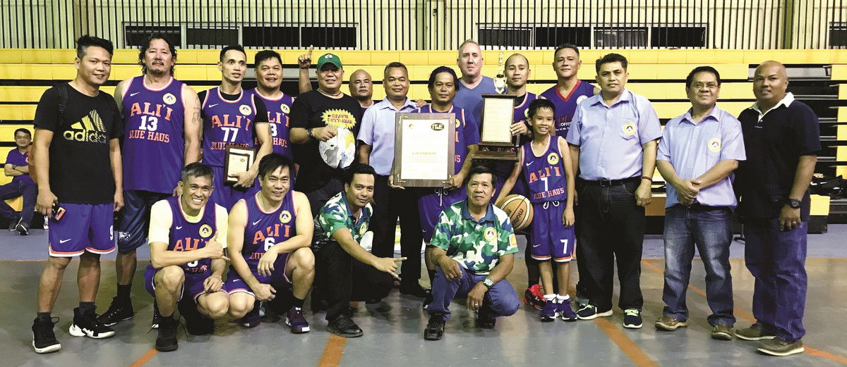 Blue Haus receives the championship trophy after demolishing JSN in the masters division finals of the UFO-IT&E Basketball League on Sunday at the Gilbert C. Ada Gym. Photo by Prince Factor