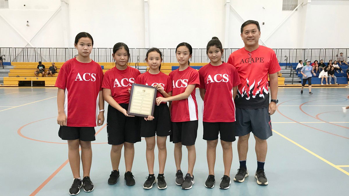 Members of the Agape Christian School girls basketball team pose with their coach, Pastor Pang, after defeating Garapan Elementary School in the title game of the PSS Interscholastic Elementary Basketball League-Girls Division on Saturday at the Marianas High School Gym.