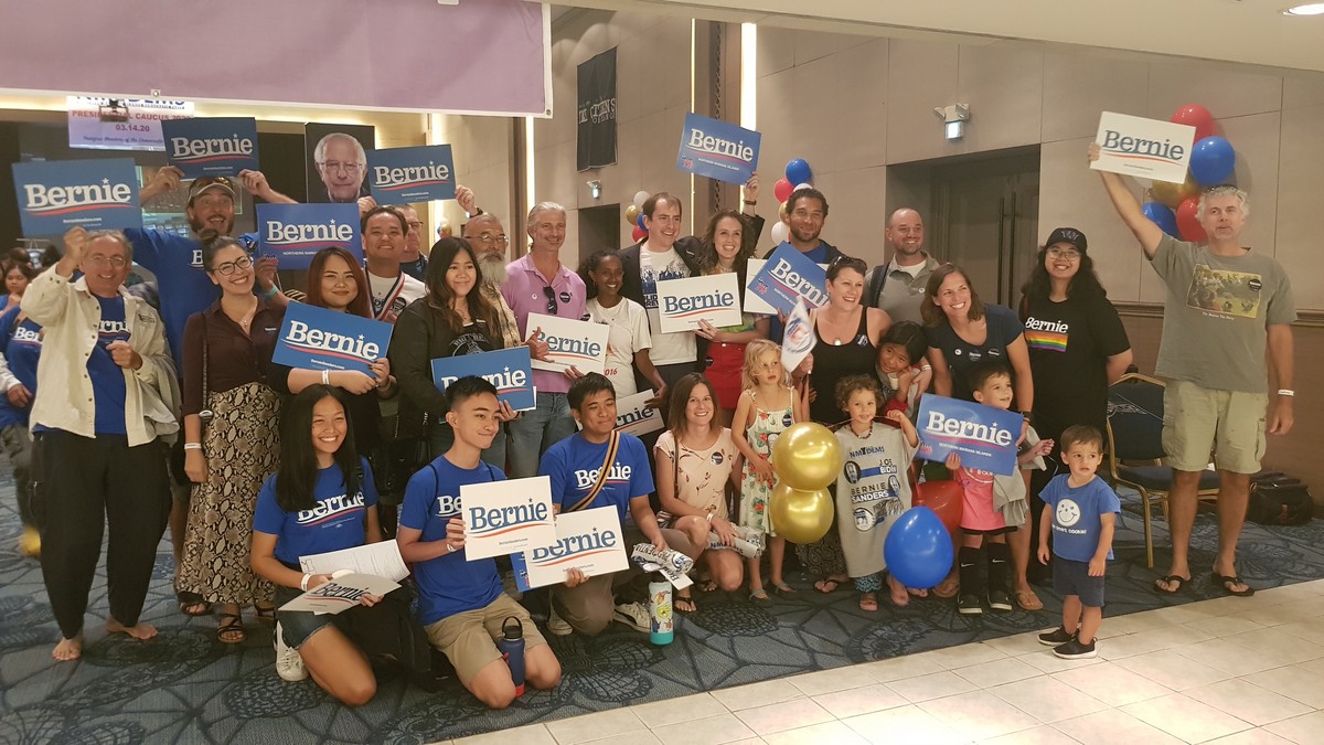 The northeast director of the Bernie Sanders campaign, Shannon Jackson, back row, fourth right, joins NMI Democrats who support Sen. Bernie Sanders during the NMI Democratic Party presidential caucus in Saipan World Resort’s Taga Hall on Saturday.