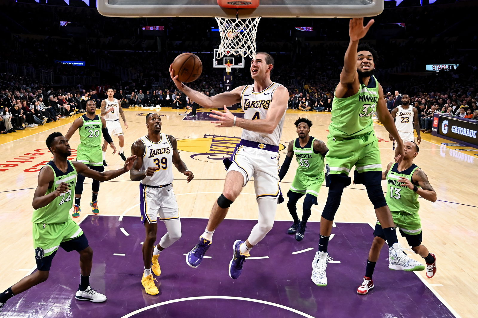 FILE - In this Dec. 8, 2019, file photo, Los Angeles Lakers' Alex Caruso (4) goes to basket under pressure from Minnesota Timberwolves' Karl-Anthony Towns (32) during the second half of an NBA basketball game in Los Angeles. Caruso was averaging 5.4 points, 1.9 rebounds and 1.8 assists in 17.8 minutes wen the hiatus began. With Avery Bradley opting out of the restart and Rajon Rondo breaking his thumb in practice this month, the 6-foot-5 Caruso should have a greater role in the Lakers’ bench during the restart. (AP Photo/Ringo H.W. Chiu, File)