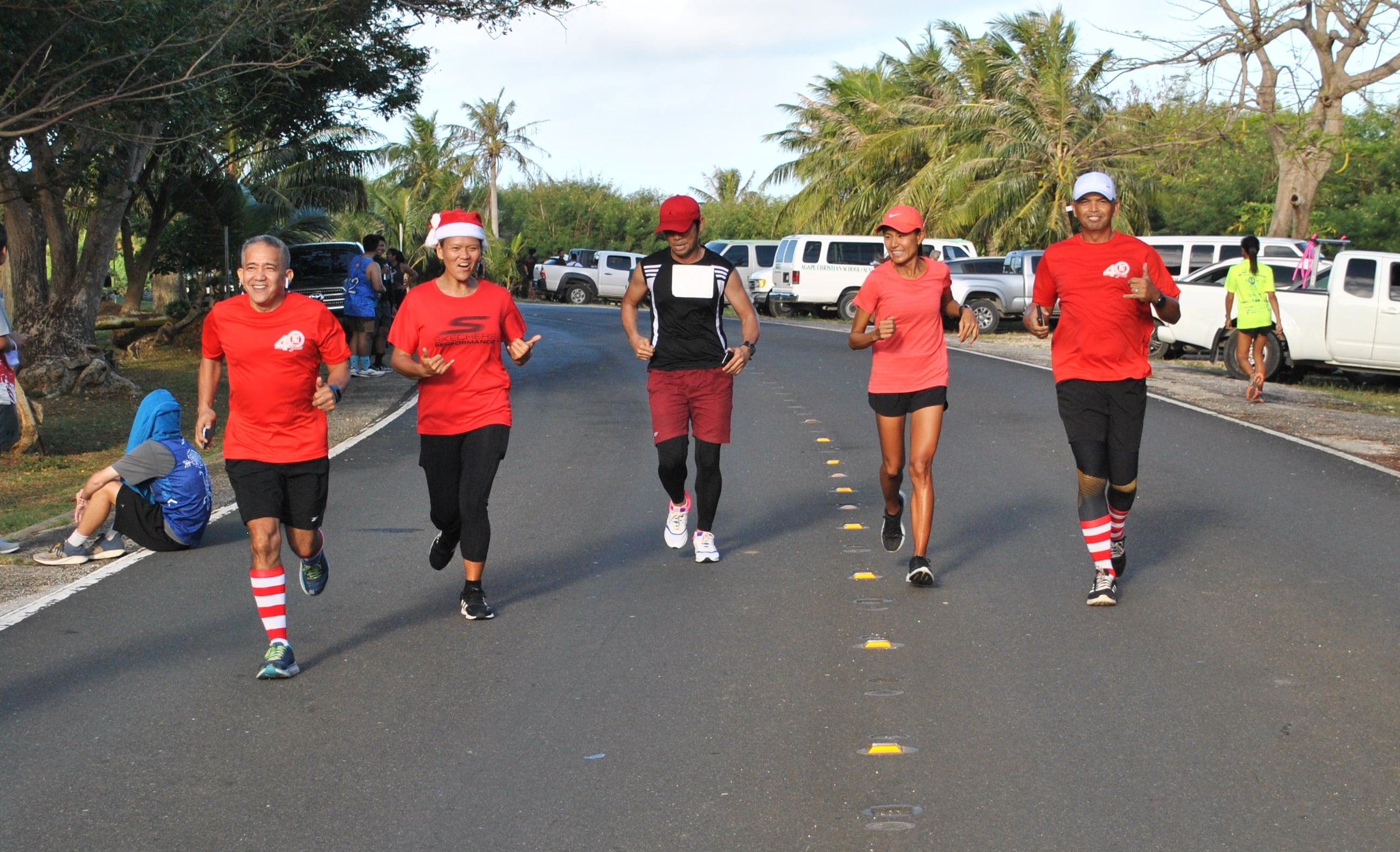 Members of Team Life in the Son-Go the Xtra Mile Run/Walk smile as they cross the finish line of the 39th Annual Christmas Island Relay at the Last Command Post on Saturday.Photo by James F. Sablan Jr.