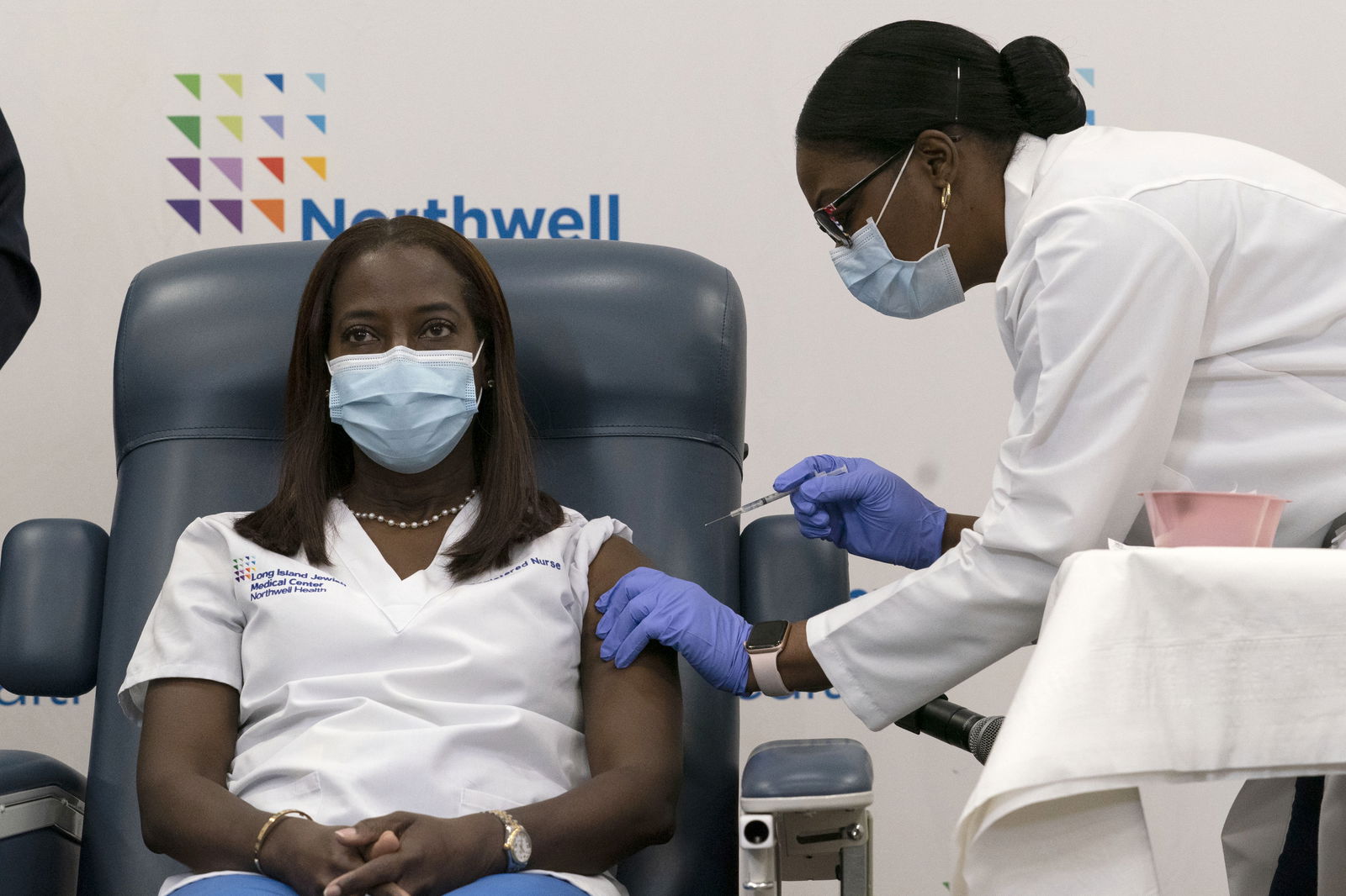 Sandra Lindsay, left, a nurse at Long Island Jewish Medical Center, is inoculated with the Pfizer-BioNTech Covid-19 vaccine by Dr. Michelle Chester, Monday, in the Queens borough of New York. AP
