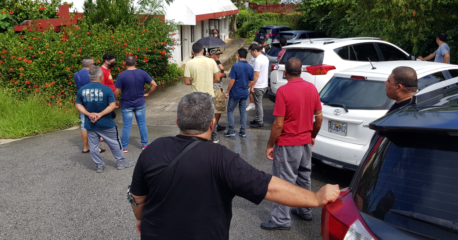 Turkish and Italian construction workers stage a protest outside the Imperial Pacific International human resources office at the Flame Tree Homes in Sadog Tasi on Friday.
