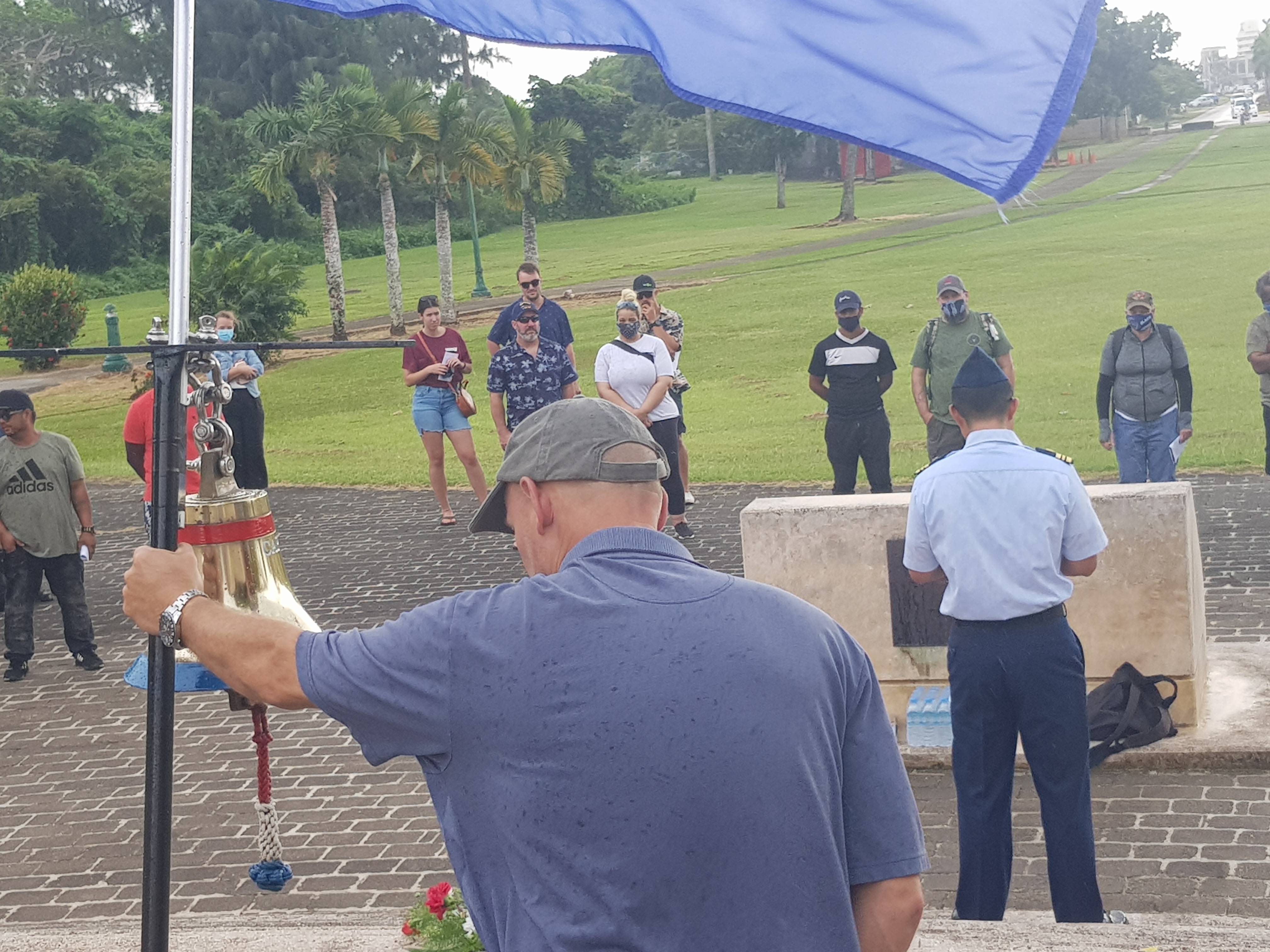 MV David I. Lyon chief mate Joseph J. Berte, back to the camera, foreground, a retired U.S. Air Force lt. colonel, holds the USAF flag while U.S. Coast Guard-Saipan Marine Safety Detachment commander Eugene Chung, right, back to the camera, reads a dedication for Capt. David Lyon while crew members looks on.Photo by Bryan Manabat