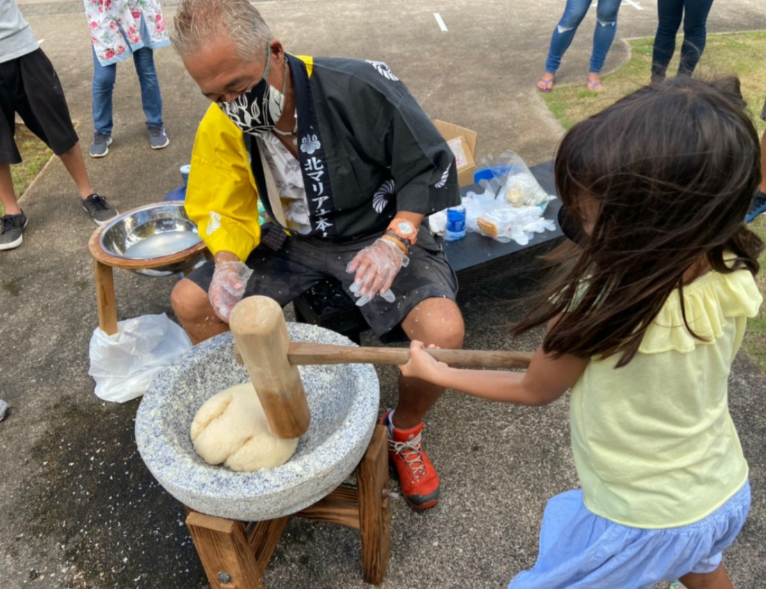 A girl pounds mochi at the Paseo De Marianas on Dec. 28 2020.Contributed photo