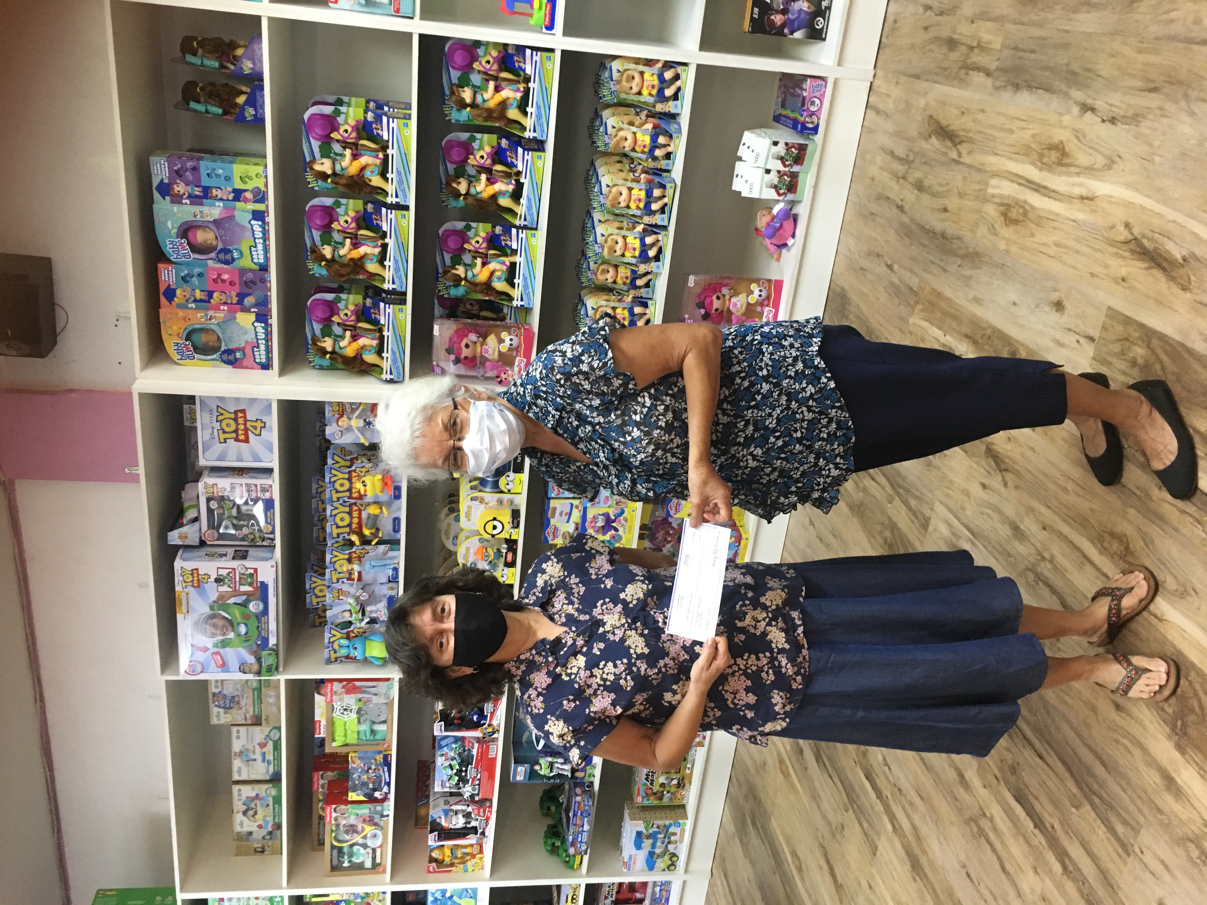 Penelope Hofschneider, left, of Lollipops hands a check for $5,000 to Agnes McPhetres, NMTI CEO.Contributed photo