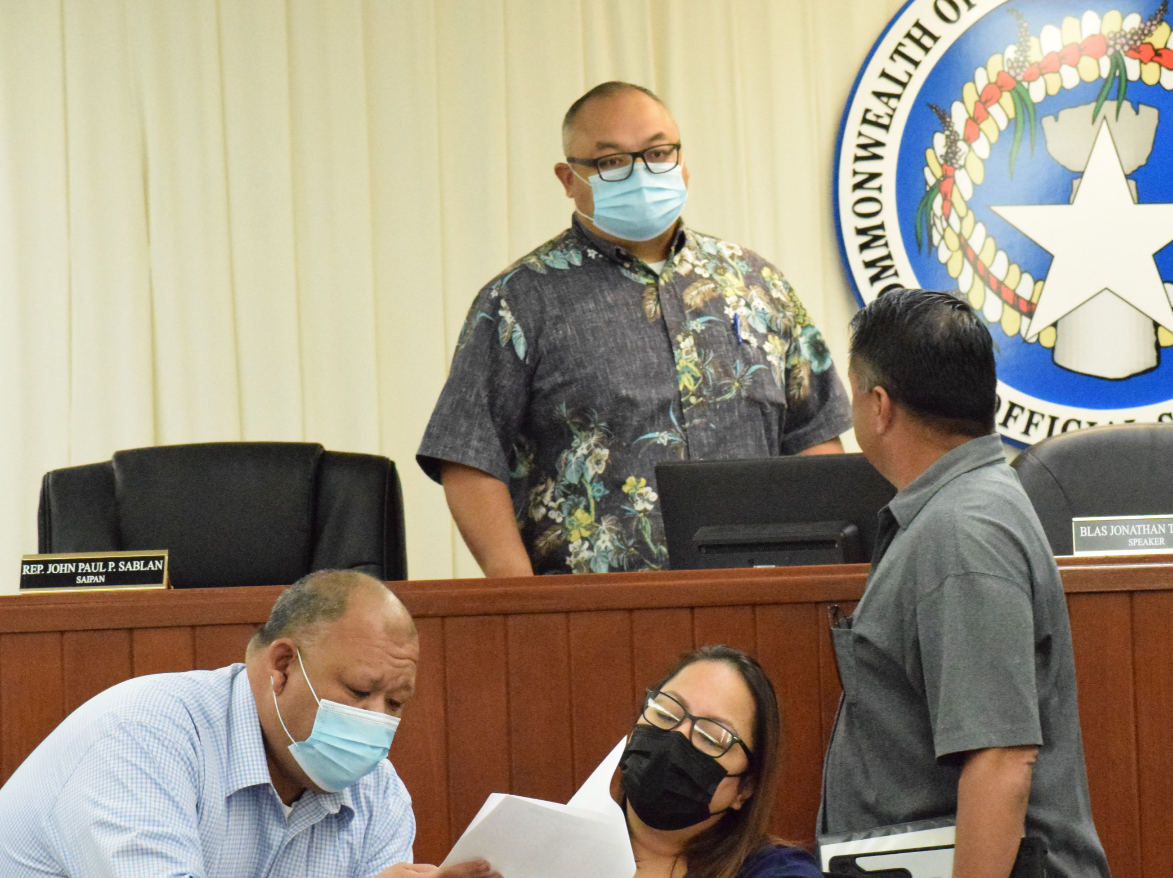 Speaker Blas Jonathan Attao, center, talks to Rep. Ralph Yumul, right, while House Floor Leader John Paul Sablan, left, shows a document to House clerk Linda Muna during the final session of the 21st House on Wednesday.Photo by Emmanuel T. Erediano