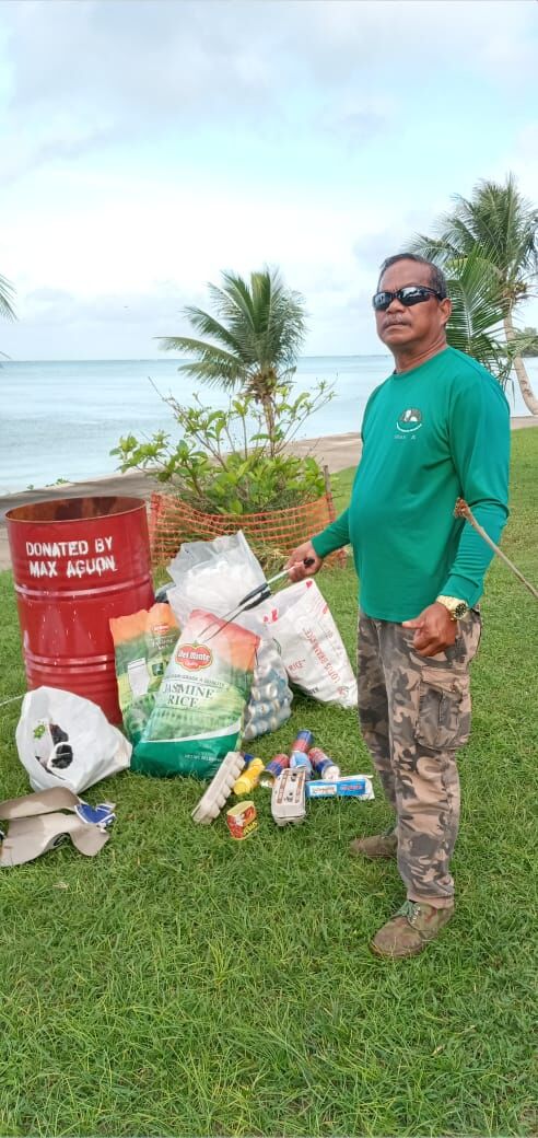 Max Aguon points to household items dumped near the 13 Fishermen Memorial in Garapan on Tuesday.Contributed photo