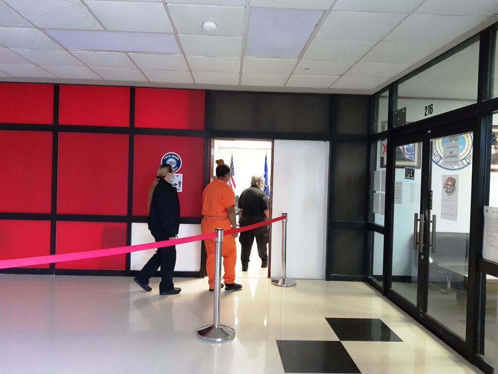 Police Officer Iris John Rangamar, center, back to the camera, is escorted by Corrections officers to a bail hearing on Monday morning.Photo by Bryan Manabat