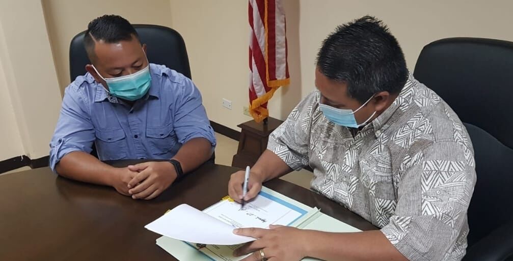Gov. Ralph DLG Torres signs Public Law 21-41 as its author, Rep. Joel Camacho, looks on.Contributed photo