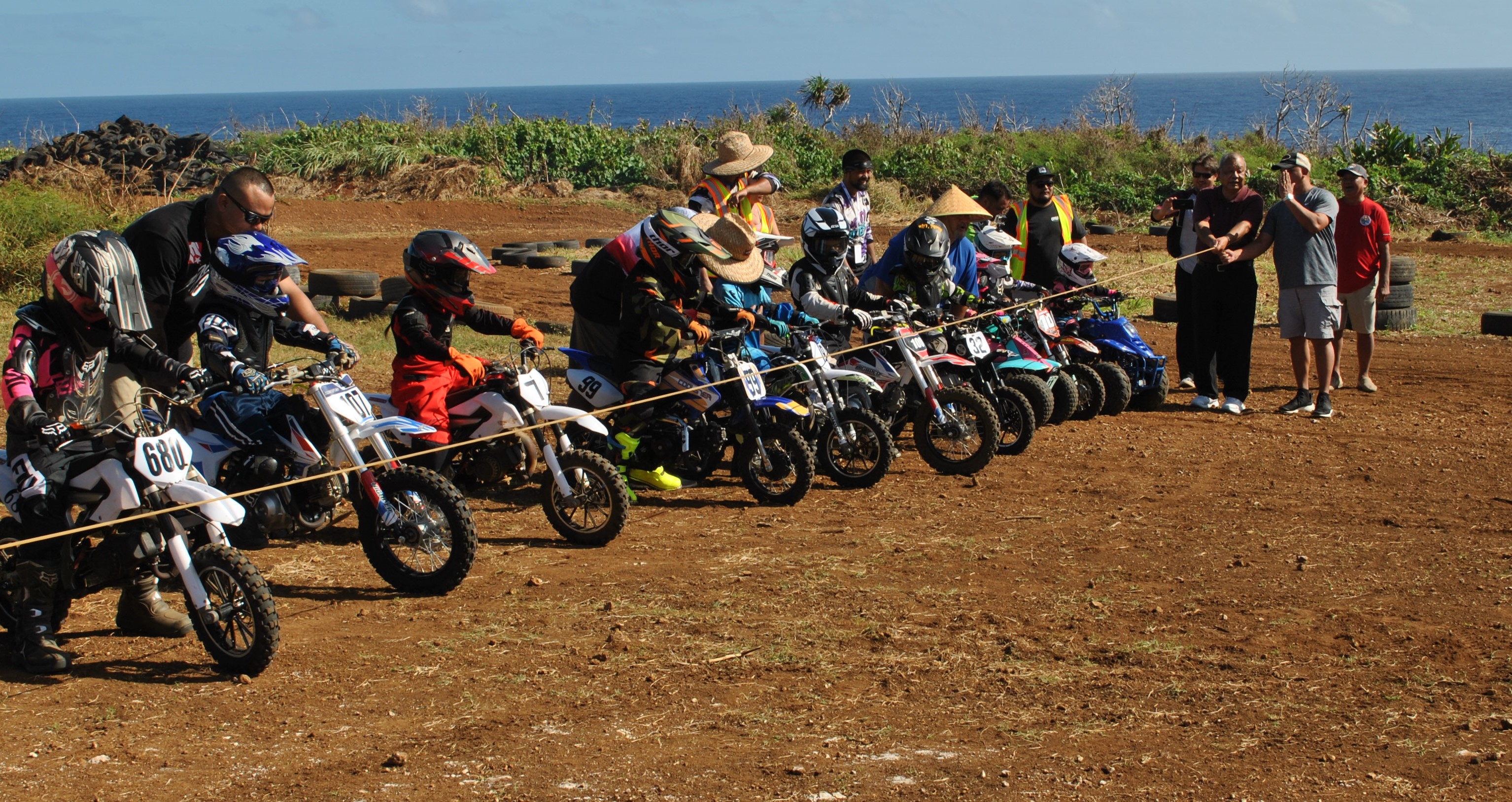 Saipan Mayor David M. Apatang holds the starting line as the Peewee 1 riders get ready for the race.