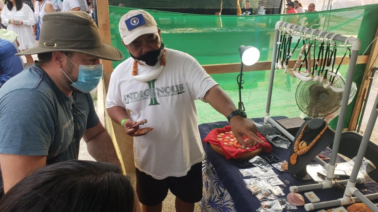 Craftsman Matthew Masga, left, explains his work to a guest on Feb. 13, 2021 at the 17th Annual Tinian Hot Pepper Festival in San Jose, Tinian.MVA photo