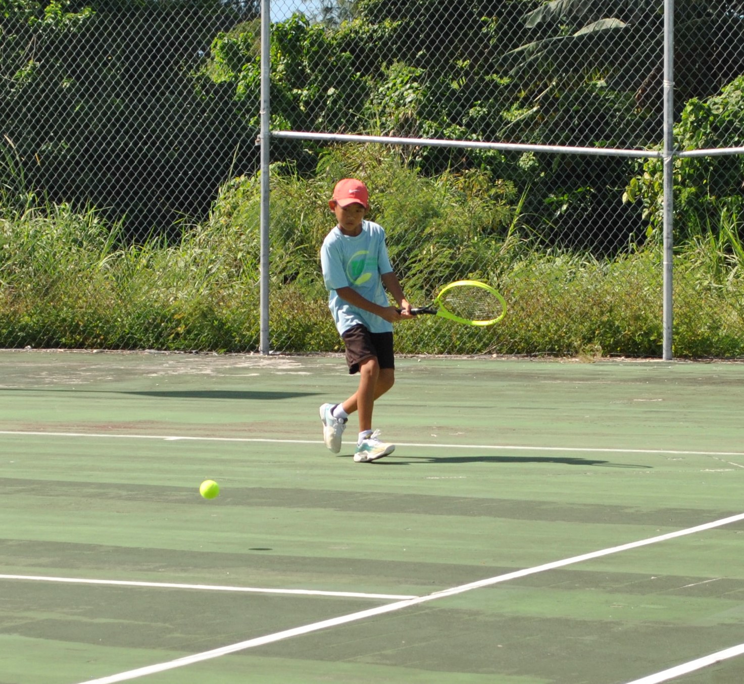 Yutaka Kadokura prepares for a backhand return during the Boys Singles-12 championship match of the 2021 White Coconut Classic on Sunday at the American Memorial Park tennis court.Photo by James F. Sablan Jr.