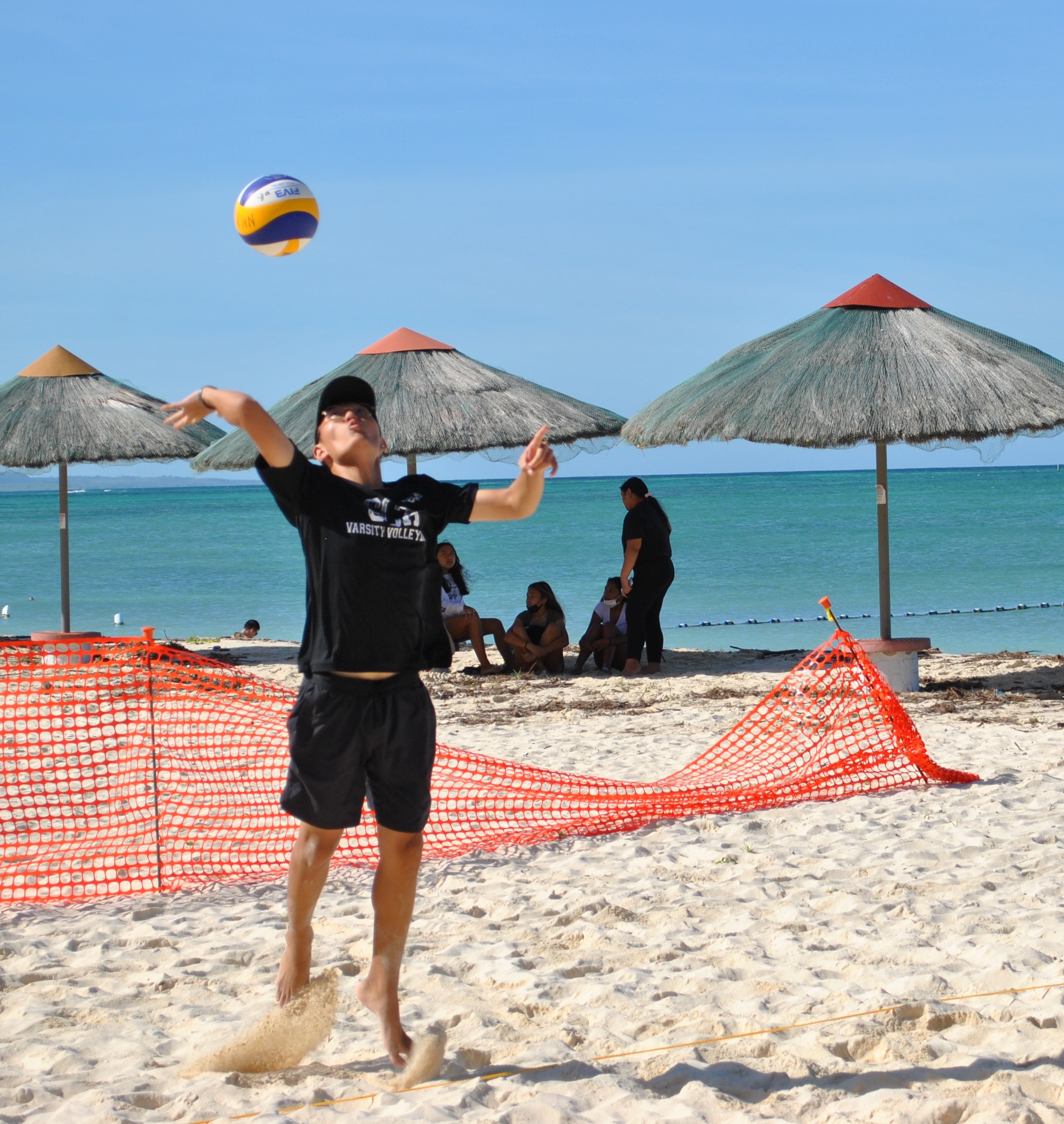 Grace Christian Academy's William Kim attempts an overhead serve during a PSS Boys 4v4 Beach Volleyball League game at the Fiesta Resort beach on Saturday.Photo by James F. Sablan Jr.