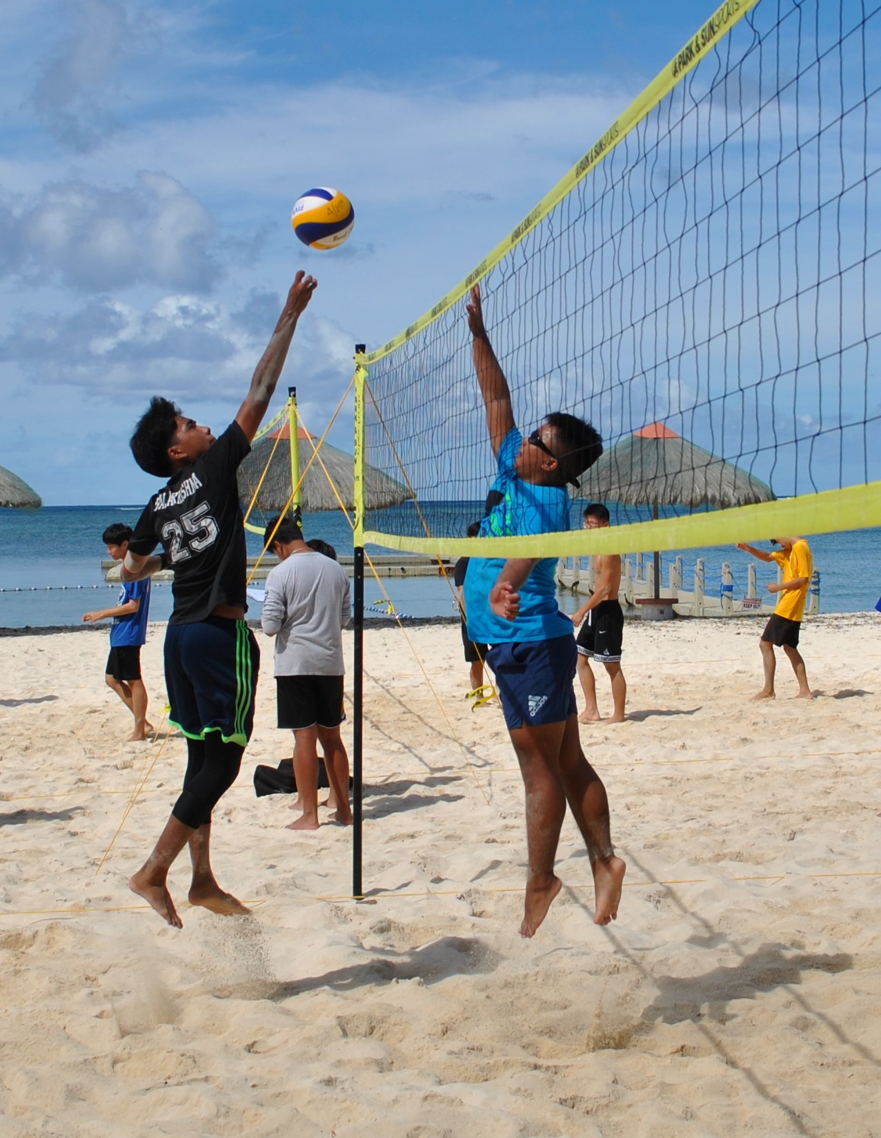 Grace Christian Academy's Steven Balakrishna tips the ball over the net against a Marianas High School 1 defender during a PSS Boys 4v4 Beach Volleyball League game at the Fiesta Resort & Spa on Saturday.Photo by James F. Sablan Jr.