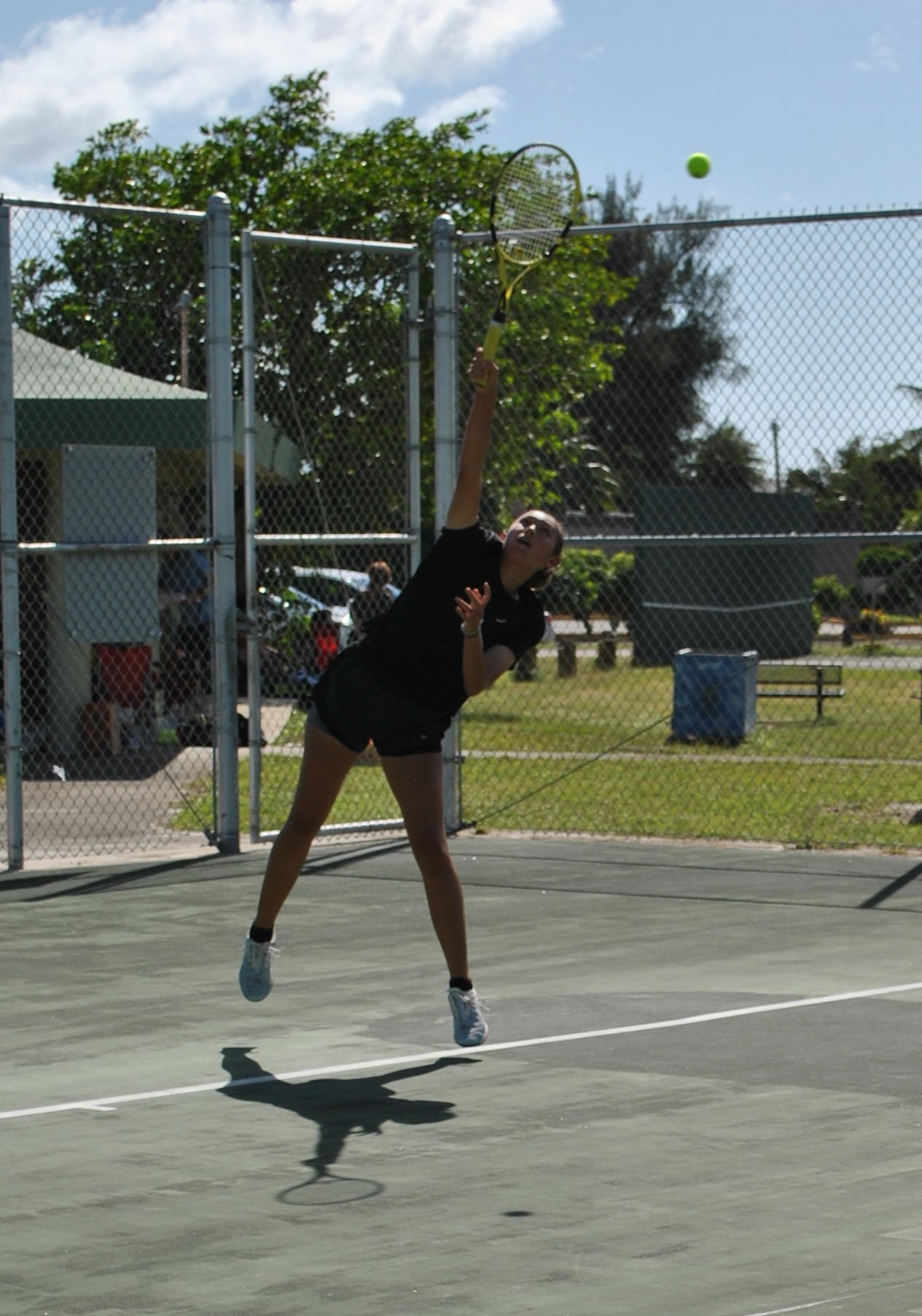Hye Jin Elliot connects the overhand serve during the women's single championship game of the 2021 White Coconut Classic on Sunday at the American Memorial Park tennis court.Photo by James F. Sablan Jr.
