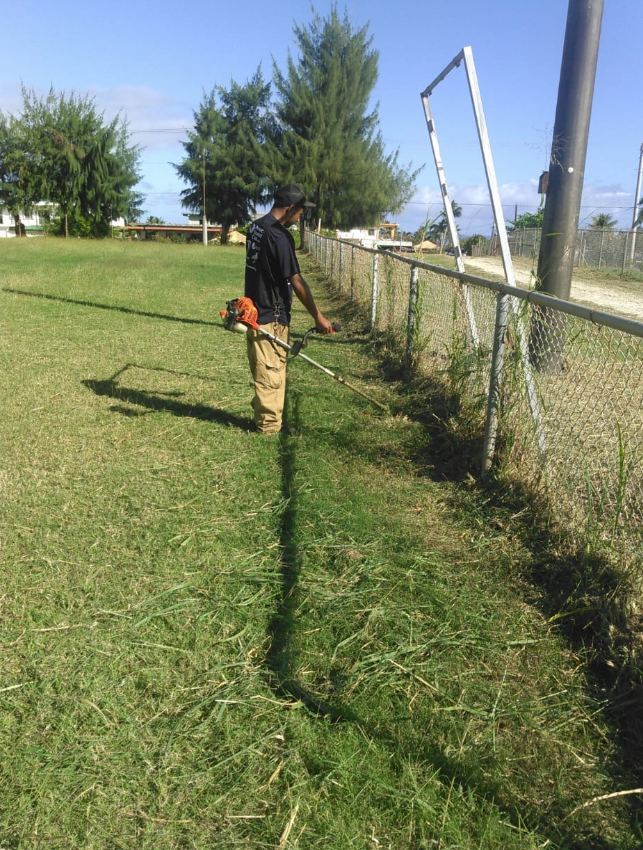 One of Rep. Edwin Propst’s community workers trims the grass on the Dandan baseball field. Facebook photo