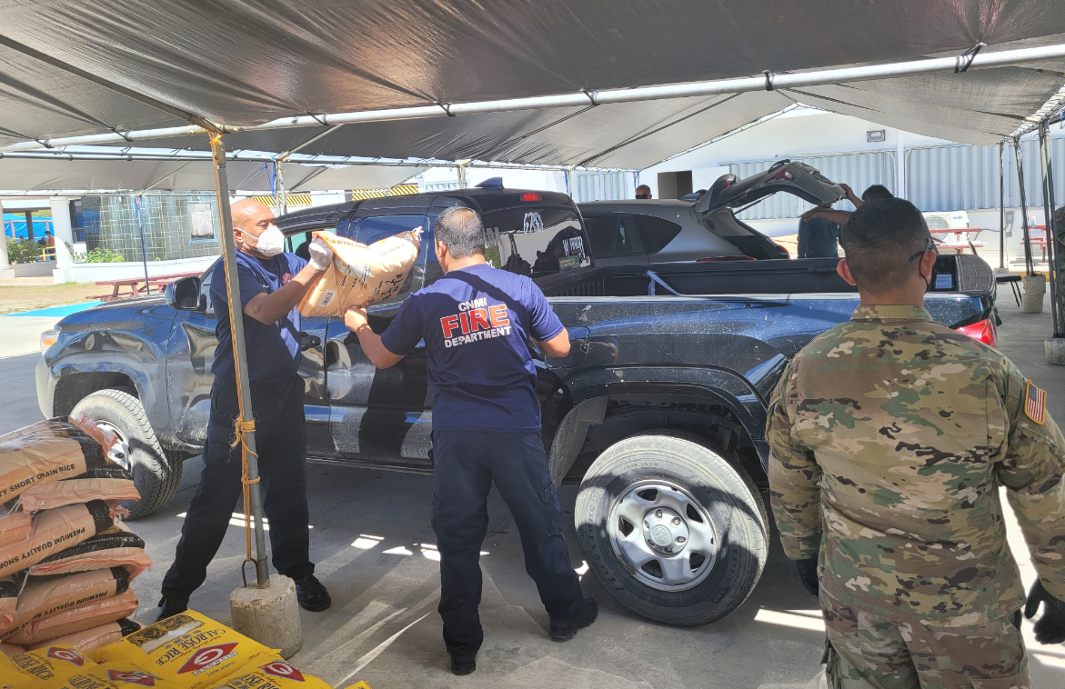 Firefighters  load a bag of rice onto a pick-up truck on Saturday at the Koblerville Youth Center.Photo by Bryan Manabat