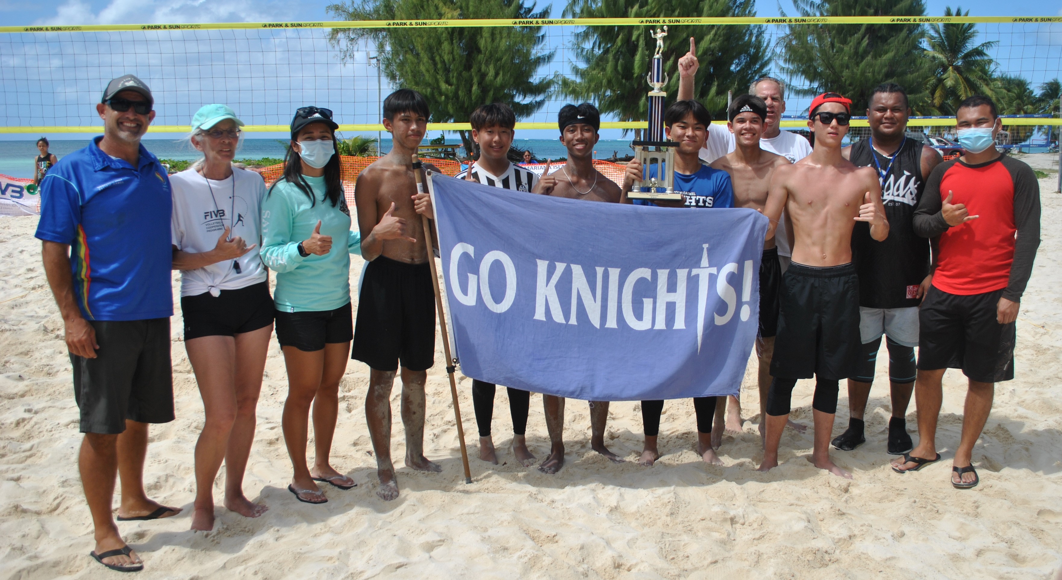 The Mount Carmel School Knights and their championship trophy with Public School System athletic director Nick Gross, left, Somia Quan, third left, and other NMI Volleyball Association officials.Photo by James F. Sablan Jr.