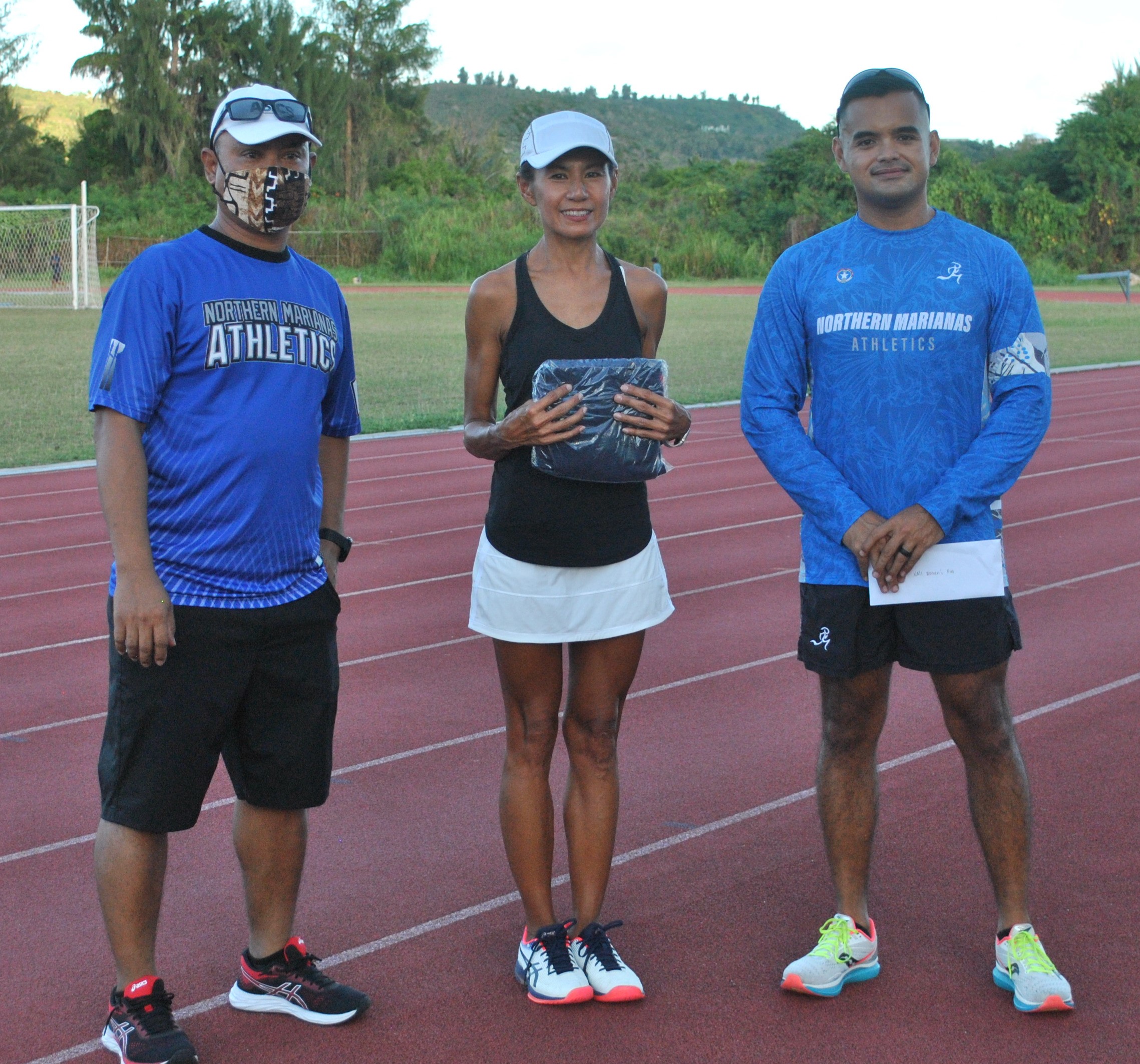 Lydia Tan of the 50-54 age group with Northern Marianas Athletics' Robin Sapong and Edward Dela Cruz Jr. during Thursday's awards ceremony at the Oleai Sports Complex.Photo James F. Sablan Jr.