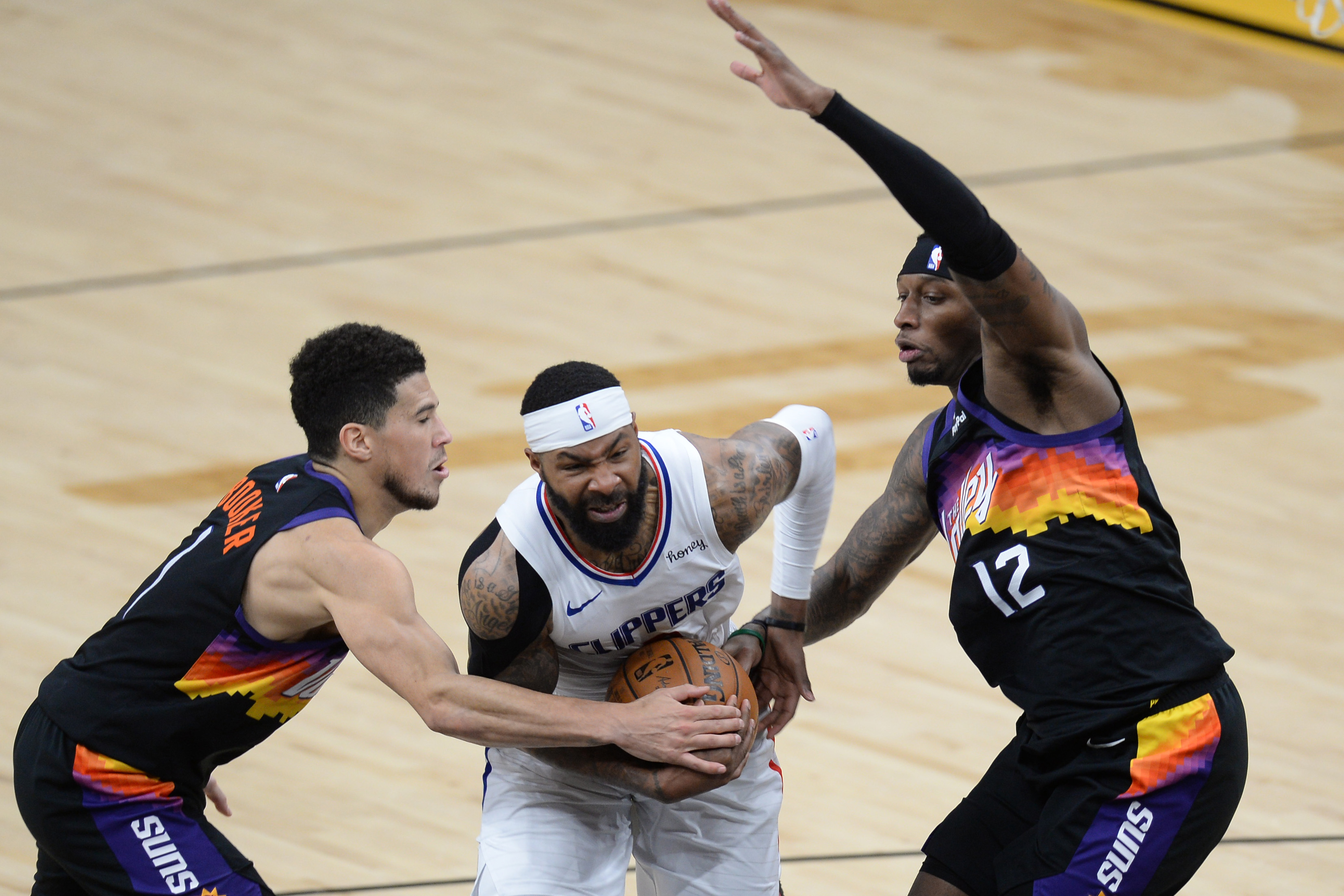 LA Clippers forward Marcus Morris Sr. (8) drives against Phoenix Suns guard Devin Booker (1) and Phoenix Suns forward Torrey Craig (12) during the second half at Phoenix Suns Arena in Phoenix, Arizona on April 28, 2021.Photo by Joe Camporeale-USA TODAY Sports