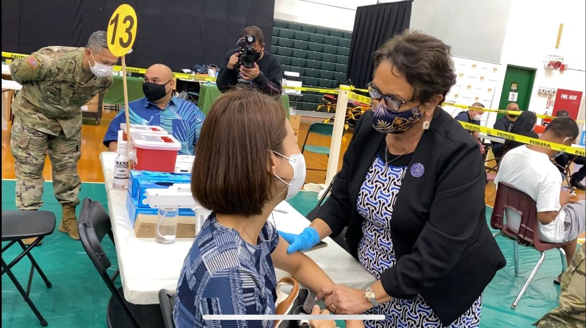 Tamuning resident Eunna Kwon talks to Gov. Lou Leon Guerrero, a registered nurse, who administered Kwon’s Covid-19 vaccine on Friday at the Guam Calvo Field House in Mangilao.Photo by Kevin Milan/The Guam Daily Post