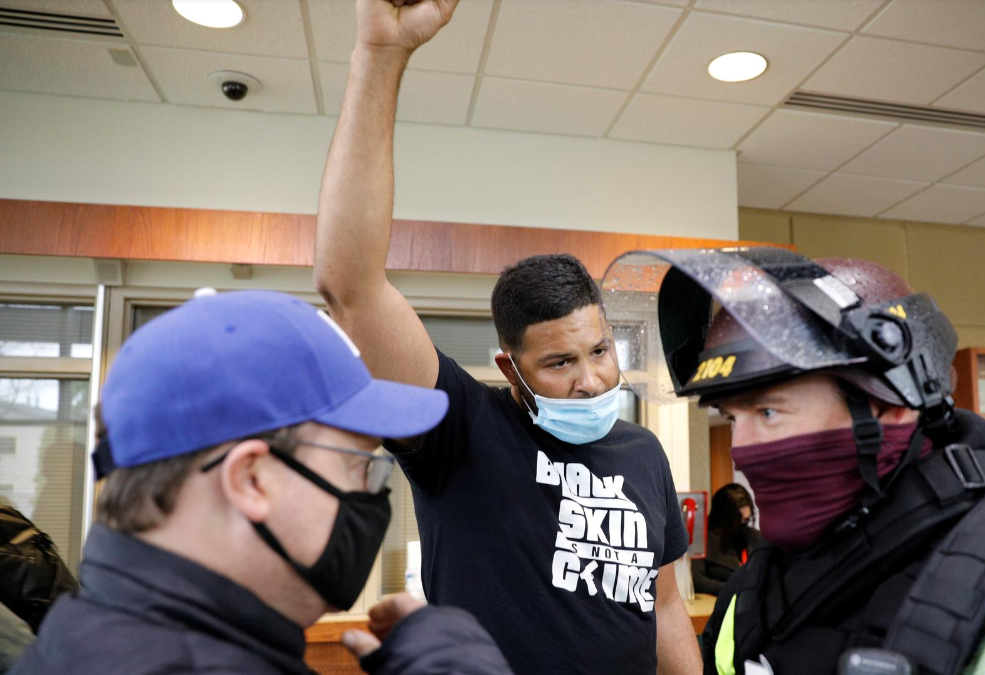 An activist confronts an officer inside the Brooklyn Center Police Department after an officer-involved killing of Daunte Wright, 20, following a traffic stop in Brooklyn Center, Minnesota on April 12, 2021.REUTERS