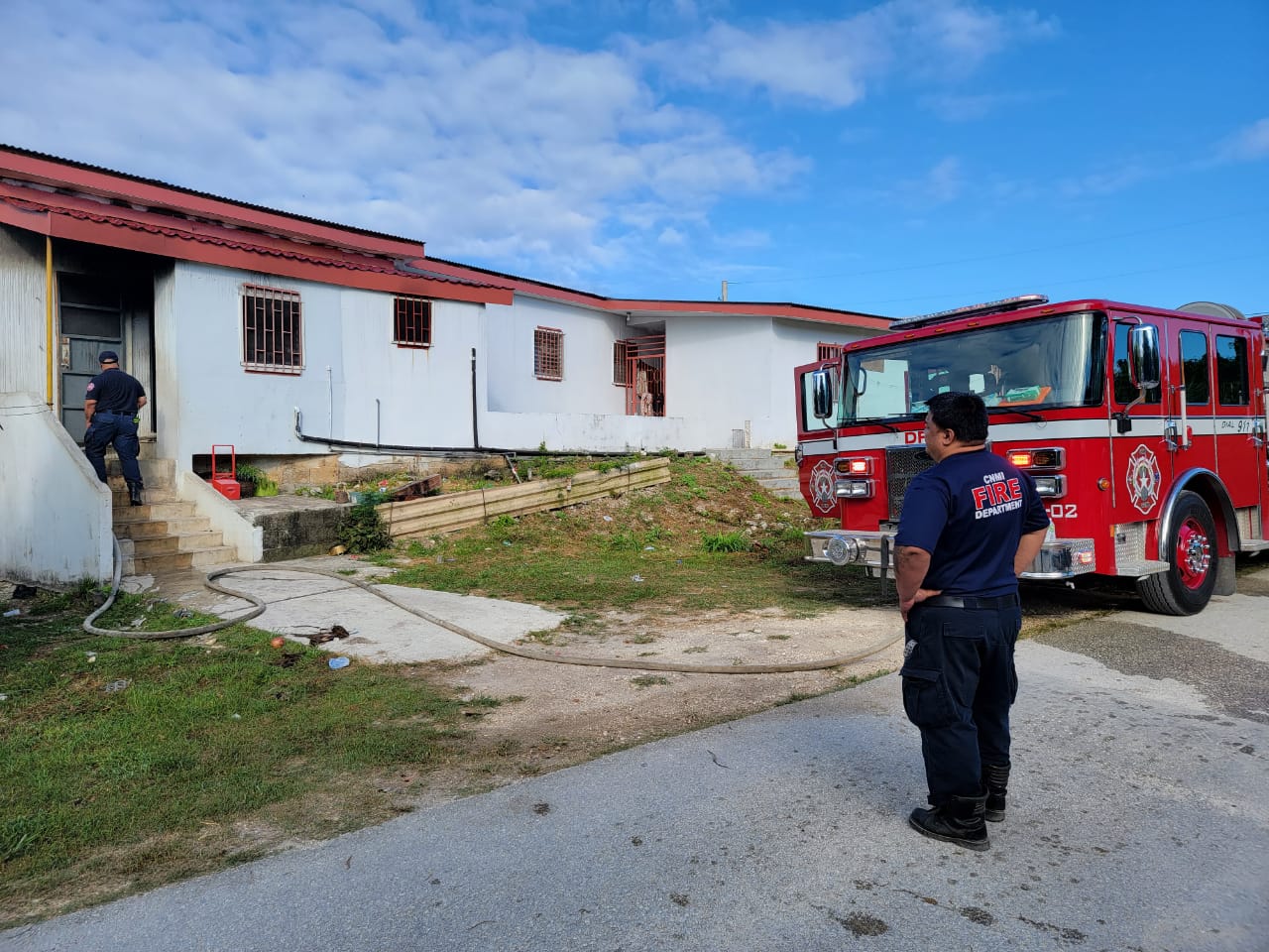 Responding firefighters are seen outside an apartment building in Afetna Thursday morning. Fire broke out in one of its units, but it was quickly extinguished by the fire department.DFEMS photo