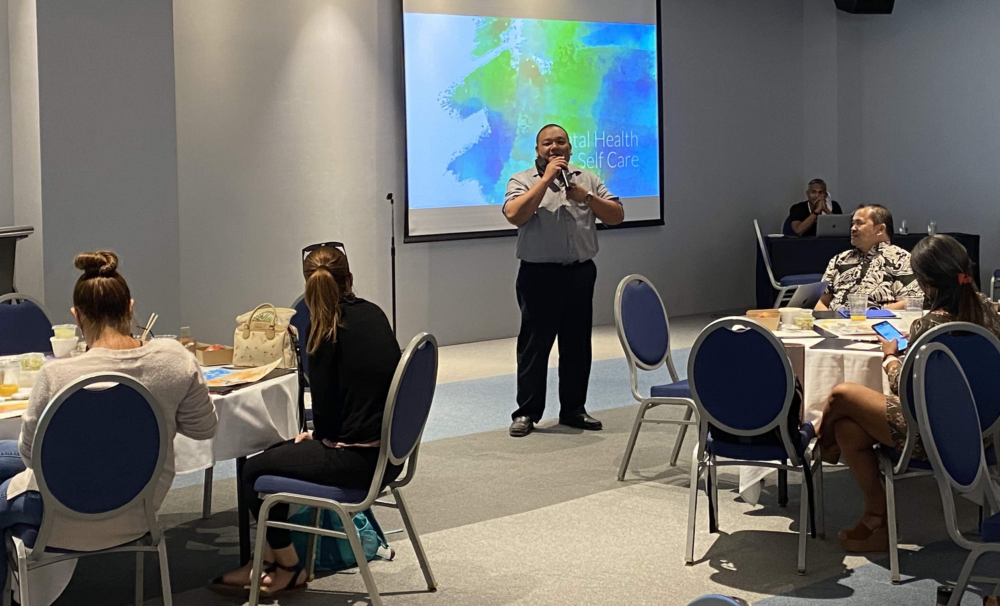 A school vice principal for 10 years, Associate Commissioner for Administration Eric Magofna, center standing, delivers his remarks.