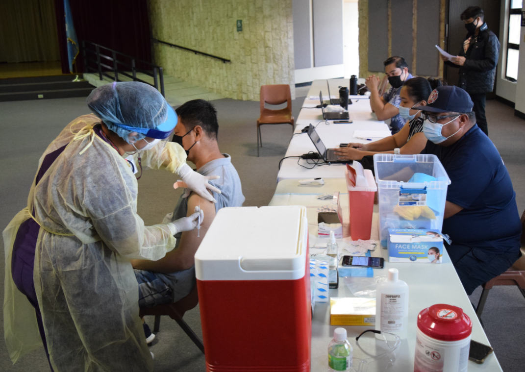 Registered nurse Evita Kawai administers a Covid-19 vaccine to a member of the community at the multi-purpose center in Susupe.Photo by Emmanuel T. Erediano