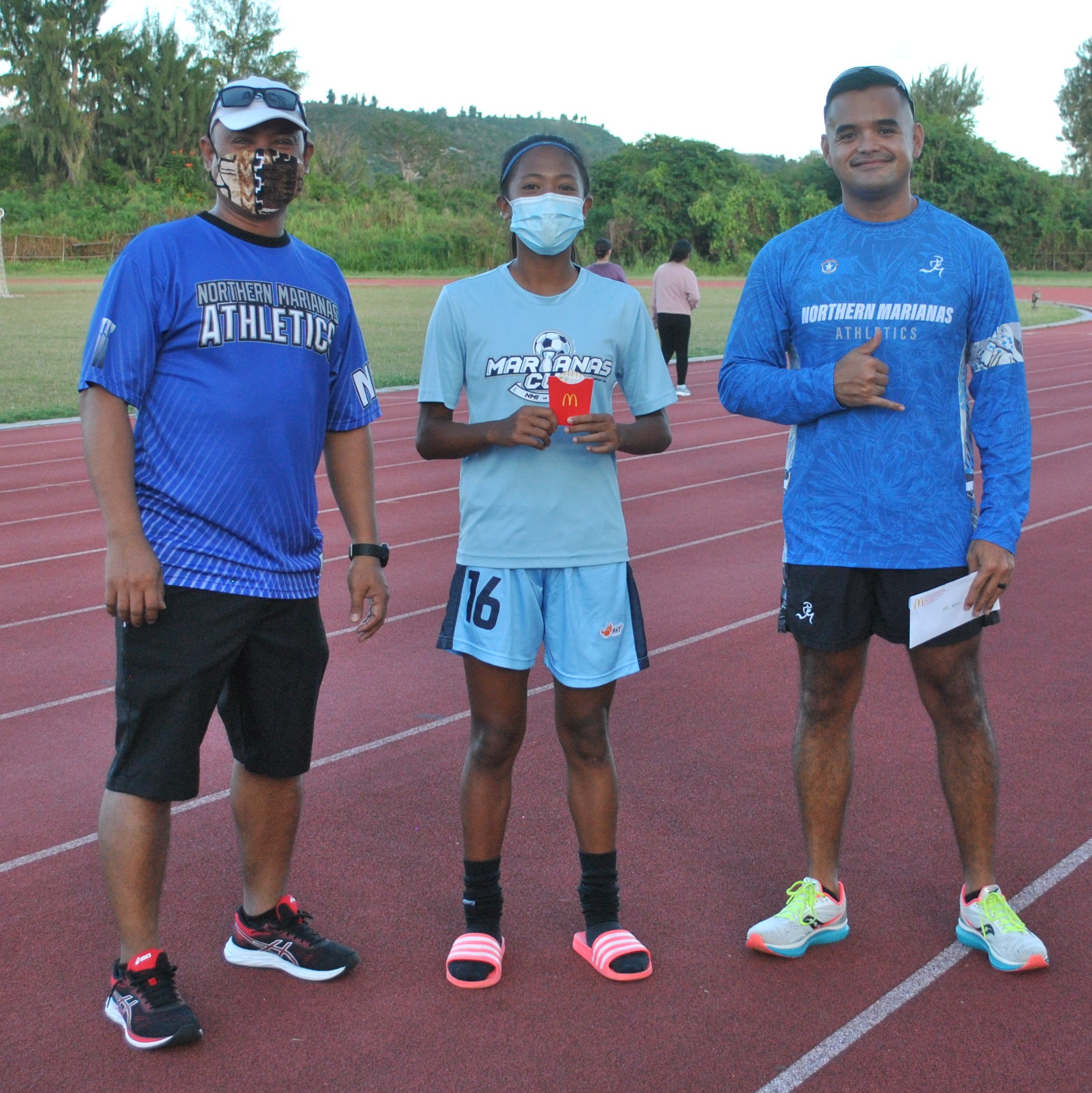 Kaithlyn Chavez of the U18 group with Northern Marianas Athletics' Robin Sapong and Edward Dela Cruz Jr. during Thursday's awards ceremony at the Oleai Sports Complex.Photo James F. Sablan Jr.