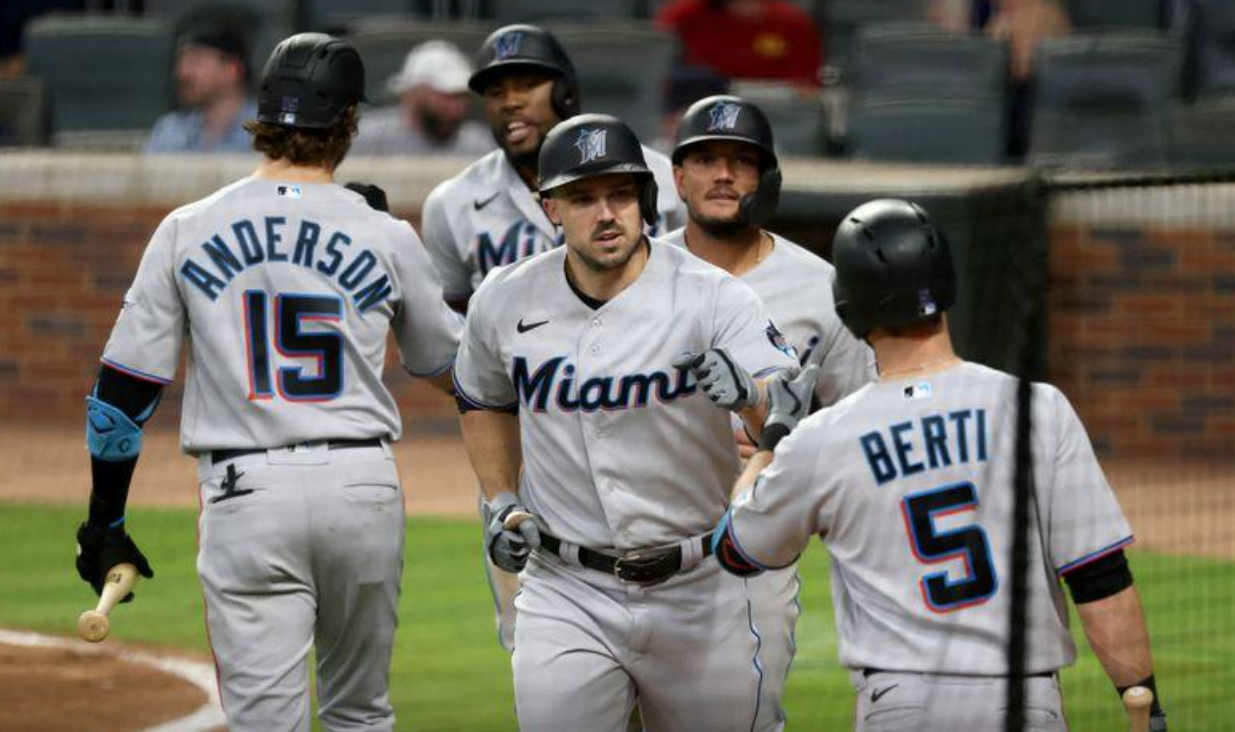 Miami Marlins left fielder Adam Duvall, center, celebrates with third baseman Jon Berti (5) after hitting a three run home run against the Atlanta Braves during the seventh inning at Truist Park in Atlanta, Georgia on April 13, 2021.Photo by Jason Getz-USA TODAY Sports
