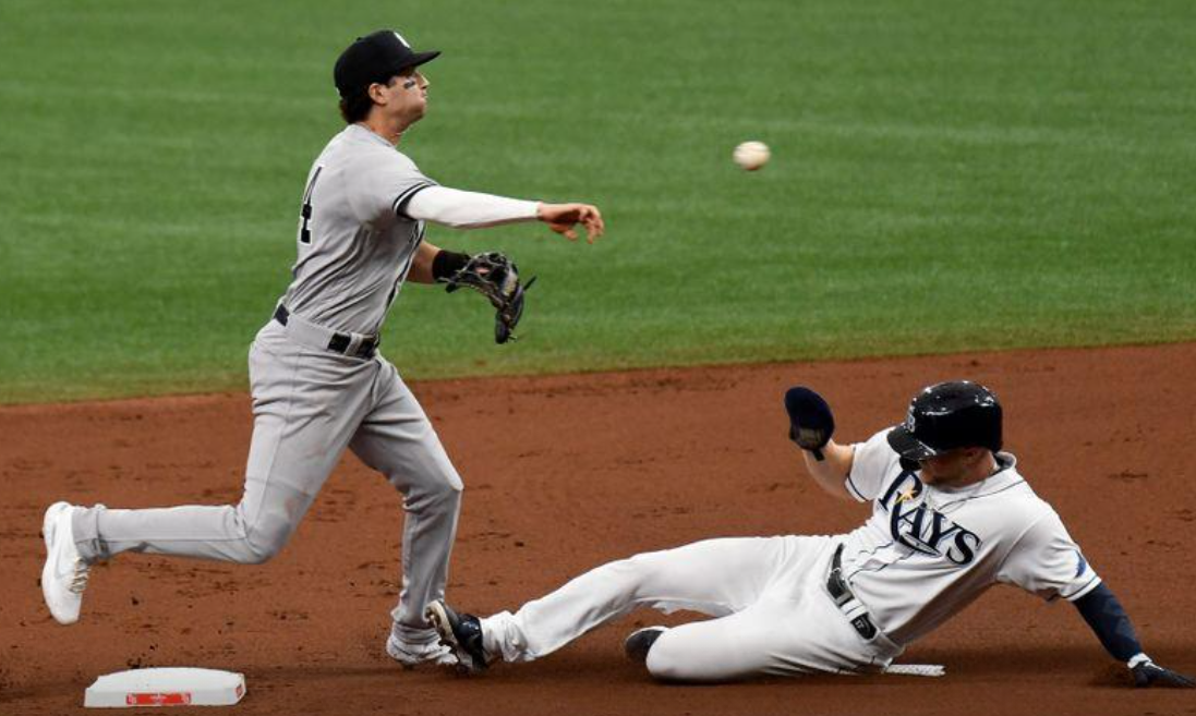 New York Yankees infielder Tyler Wade (14) throws to first base as Tampa Bay Rays outfielder Austin Meadows (17) slides in the first inning at Tropicana Field in St. Petersburg, Florida on April 9, 2021.Photo by Jonathan Dyer-USA TODAY Sports