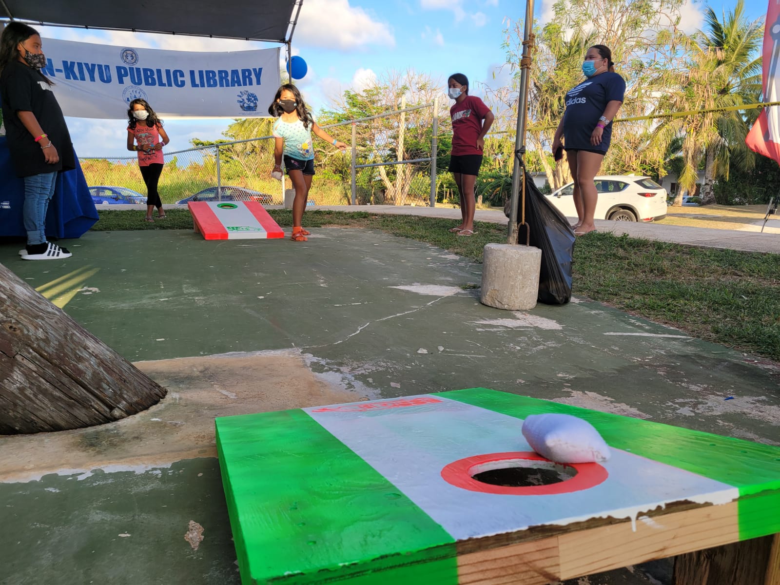 A girl tries the corn-hole/bean bag game at the Joeten-Kiyu Public Library canopy.Photo by Emmanuel T. Erediano