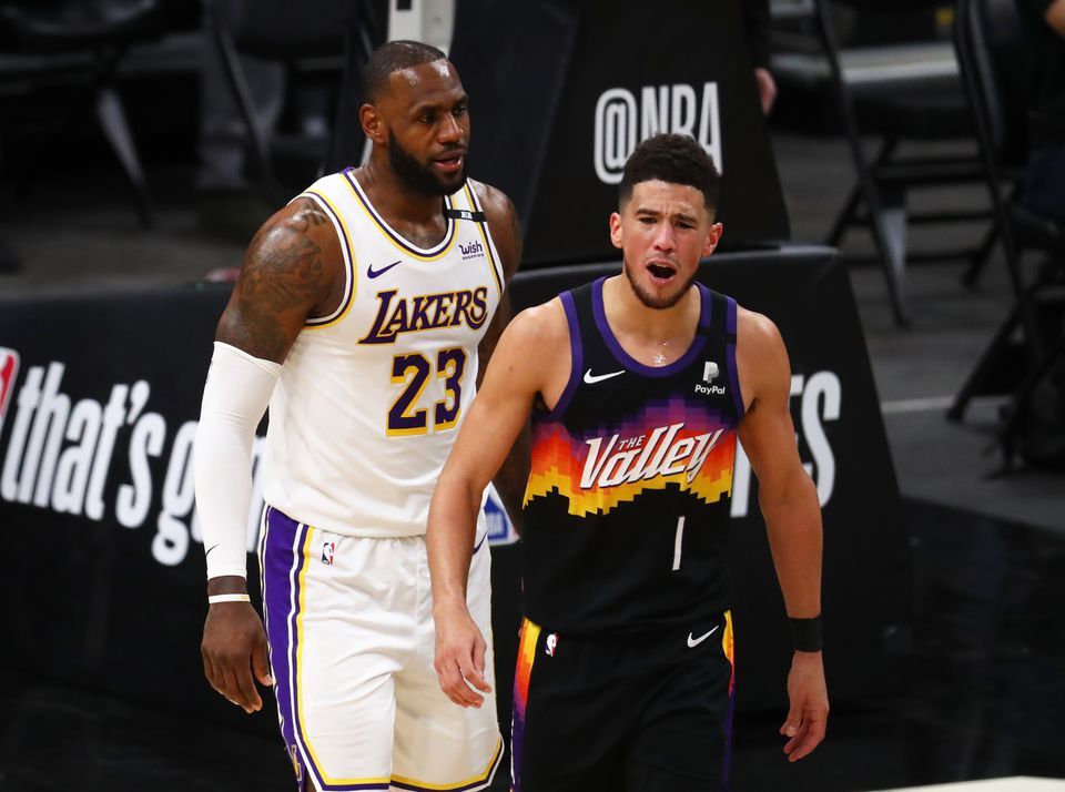 Phoenix Suns guard Devin Booker (1) reacts alongside Los Angeles Lakers forward LeBron James (23) in the first half during game one in the first round of the 2021 NBA Playoffs at Phoenix Suns Arena on May 23, 2021.Photo by Mark J. Rebilas-USA TODAY Sports