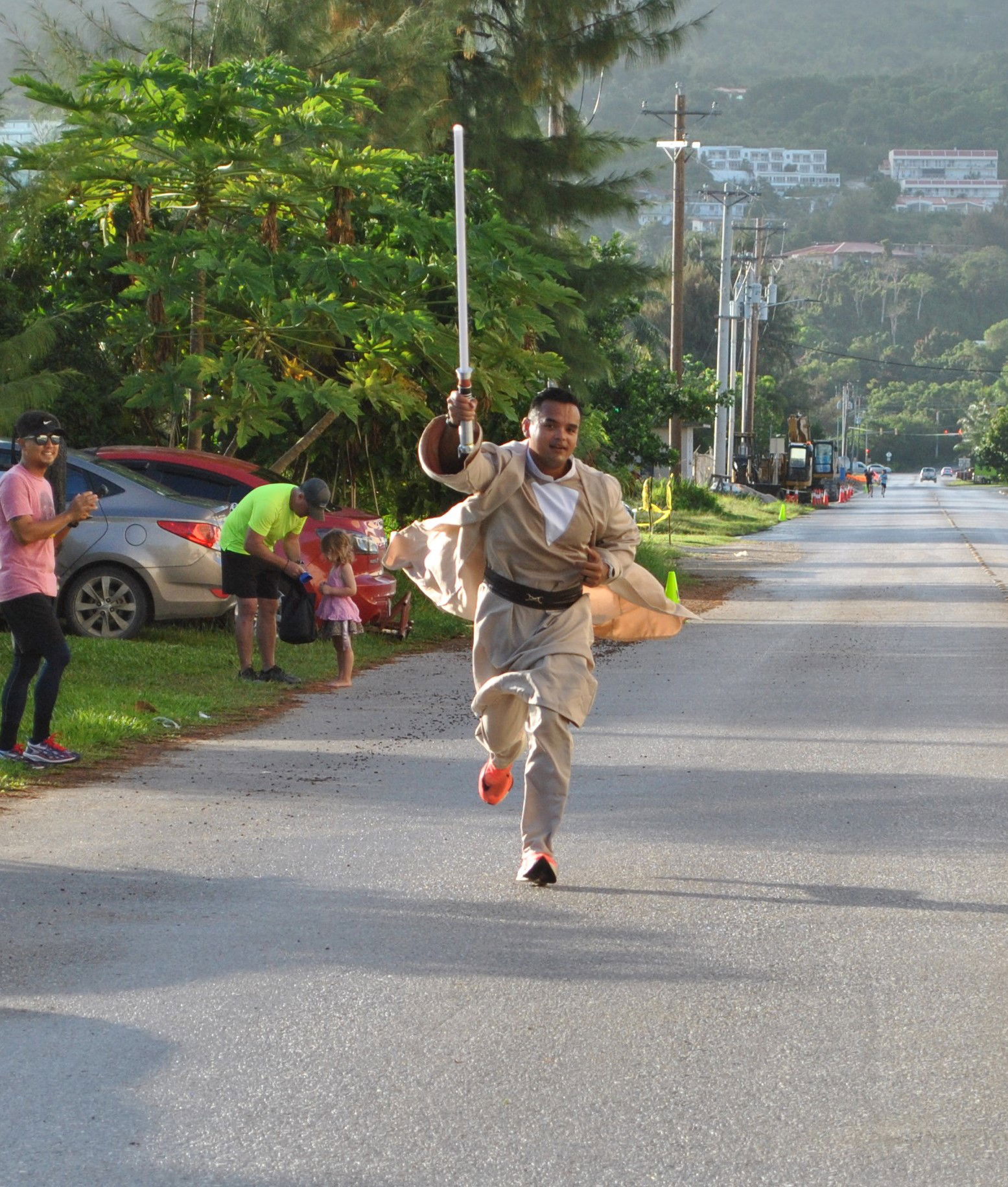 Edward Dela Cruz holds up his lightsaber as he makes his way toward the finish line.